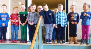 KIds on ste ps of Hartz Center