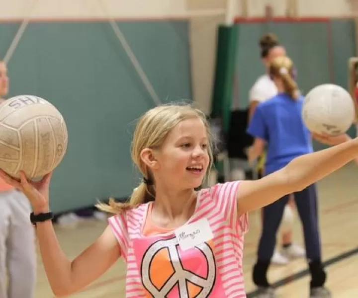 Little girl serving a volleyball