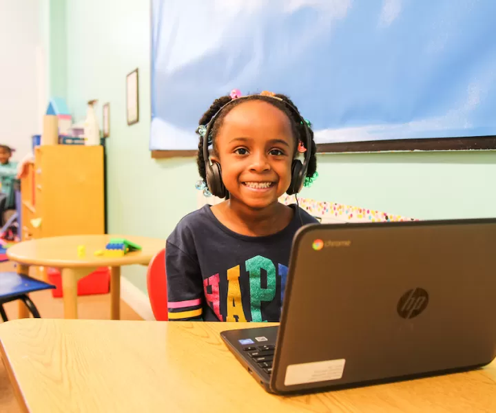 Little girl with headphones at computer