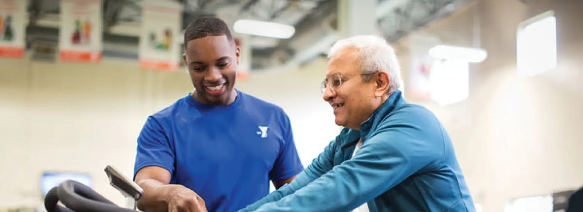 Fitness instructor helping member on a bike