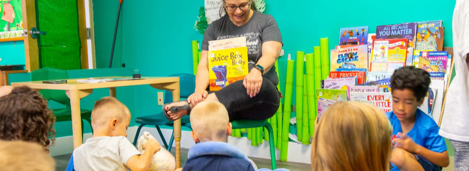 Woman reading a book to young children