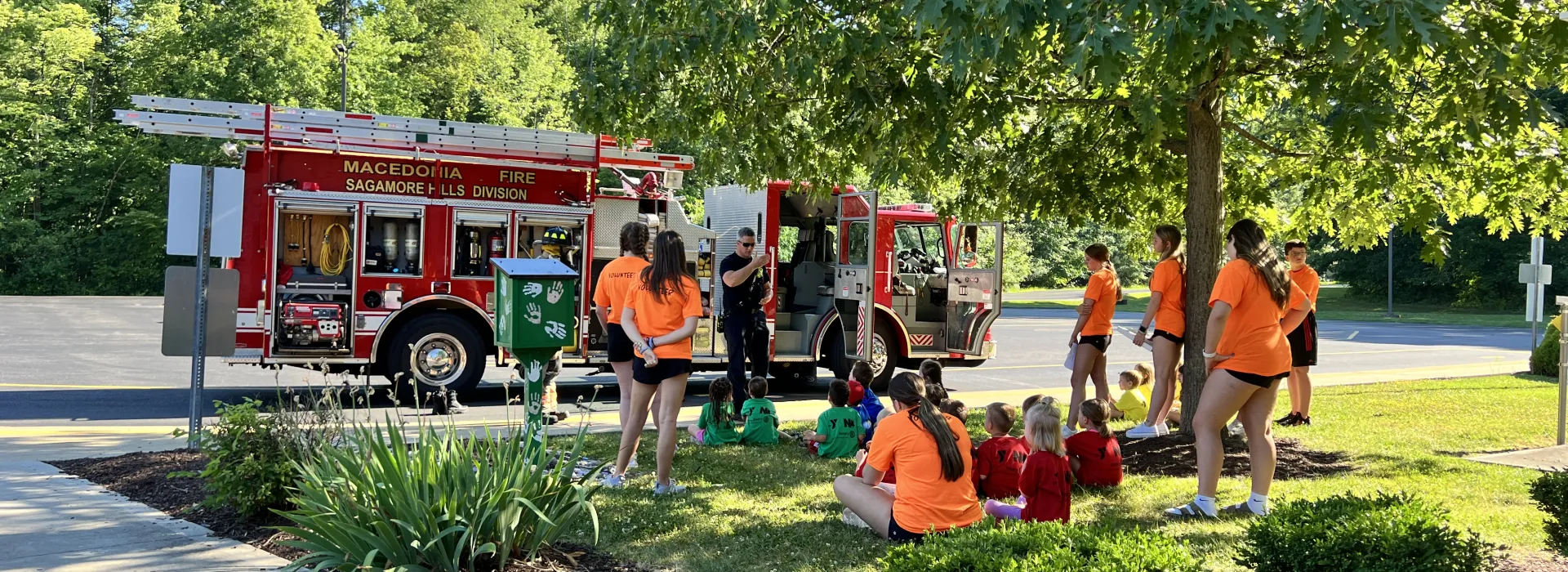 Kids outside learning from firefighters
